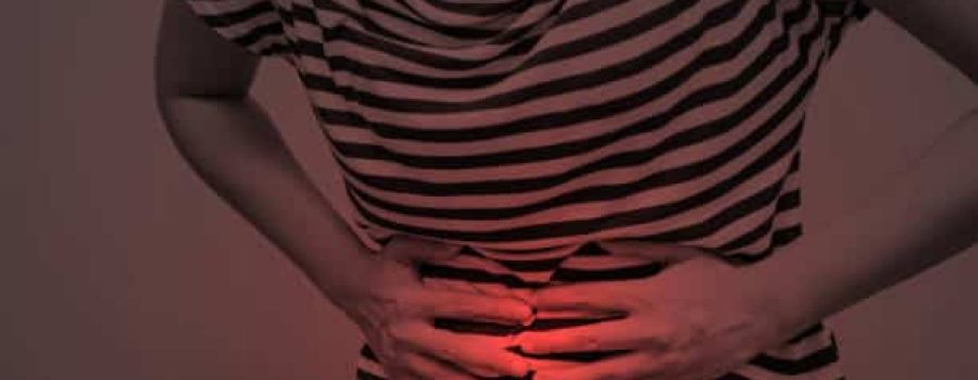 Young woman having abdominal pain, upset stomach or menstrual cramps